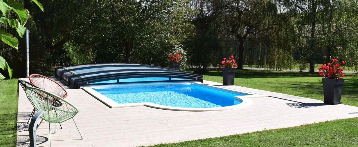 Low motorised Azenco pool enclosure over an oval pool
