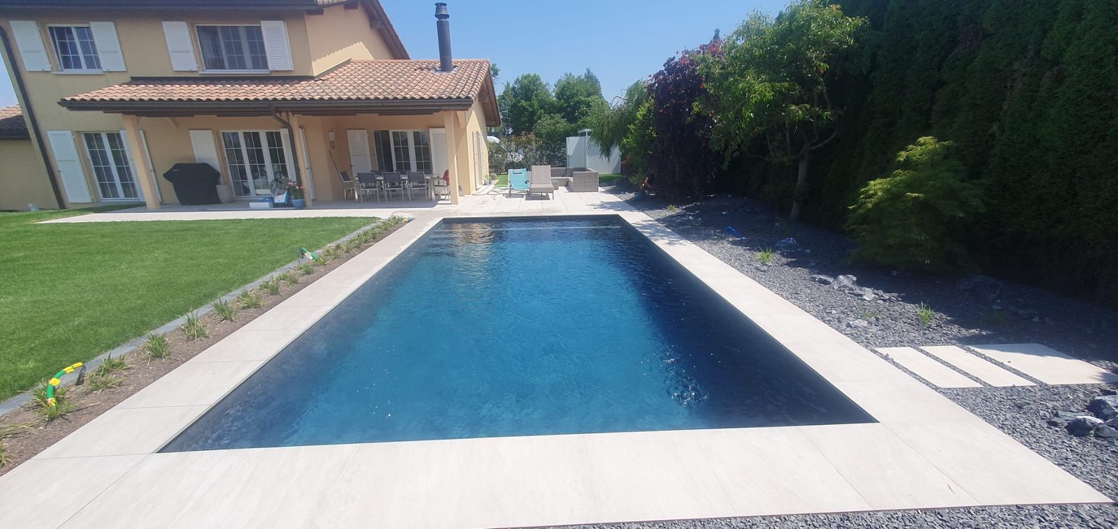 Piscine béton terminée en PVC 3D Elegance, eau bleu profond, villa et jardin paysager