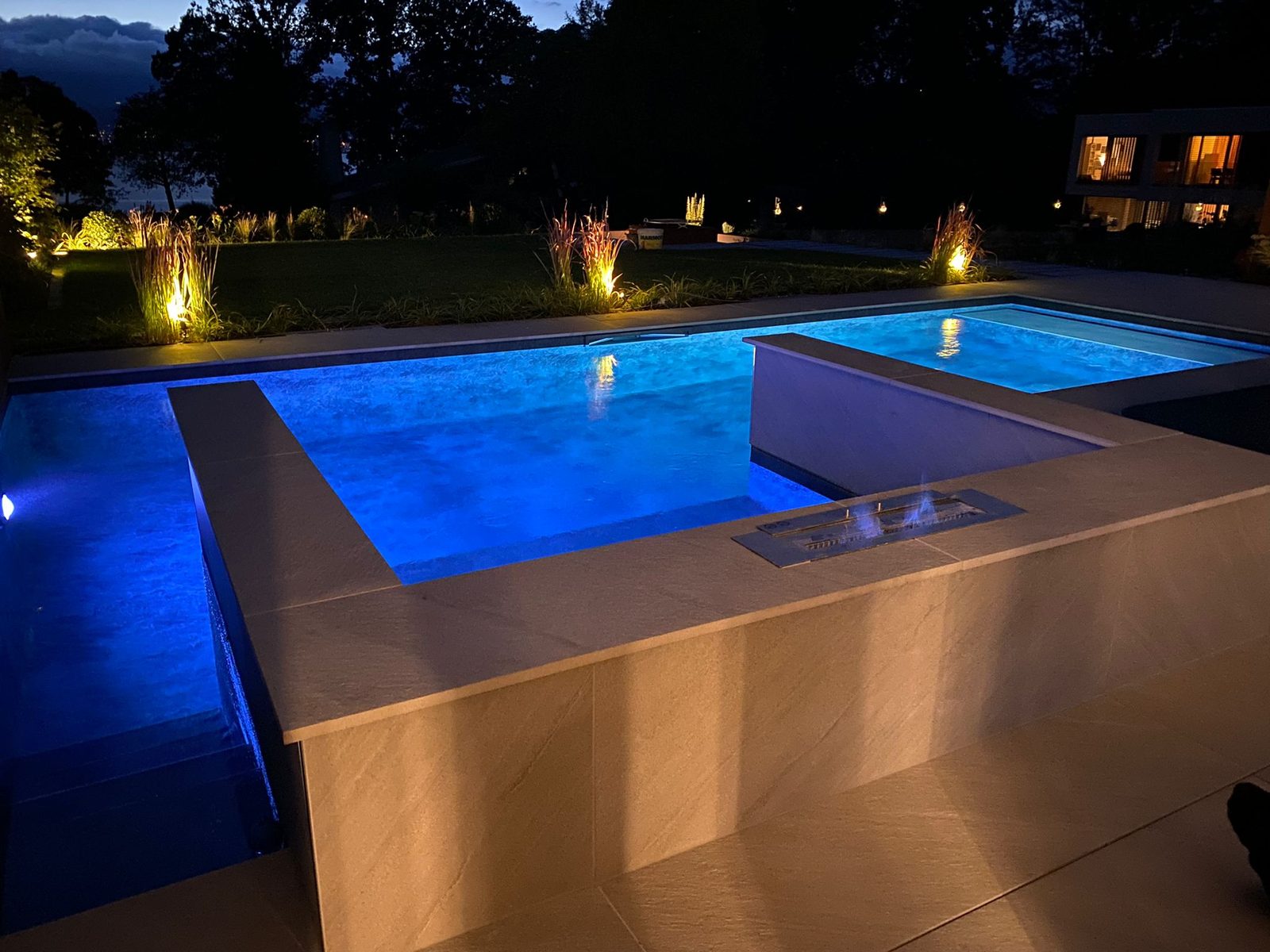 Piscine et spa intégré éclairés de nuit, réalisation Swiss Piscine