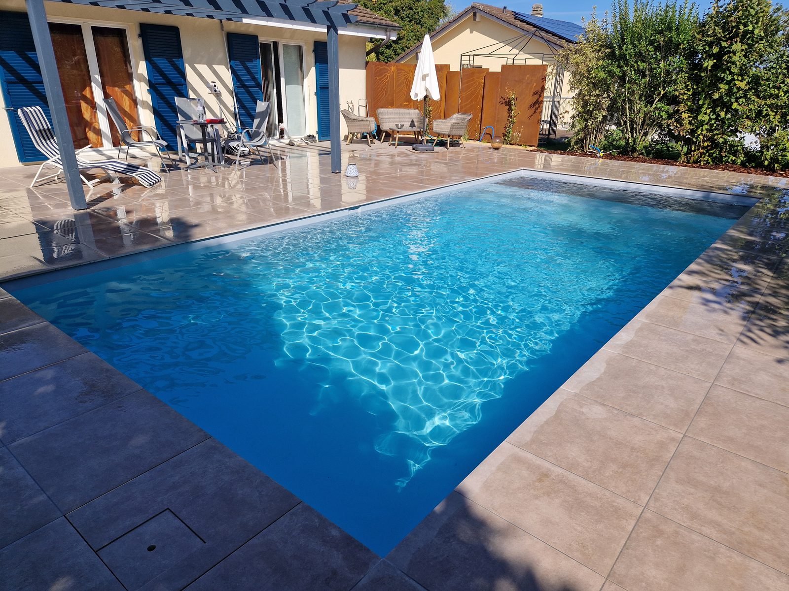 Swiss Piscine project: AKOYA fibreglass pool in Yvonand, shimmering water and pergola
