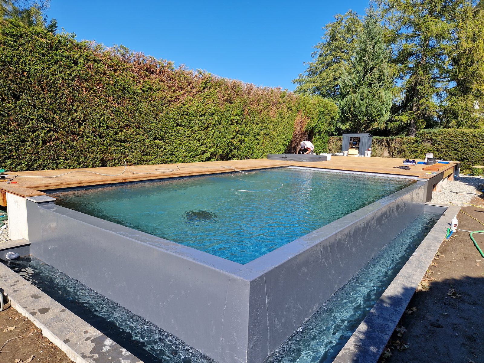 Swiss Piscine infinity pool in Gletterens, crystal-clear water and a sheet of water over the wall