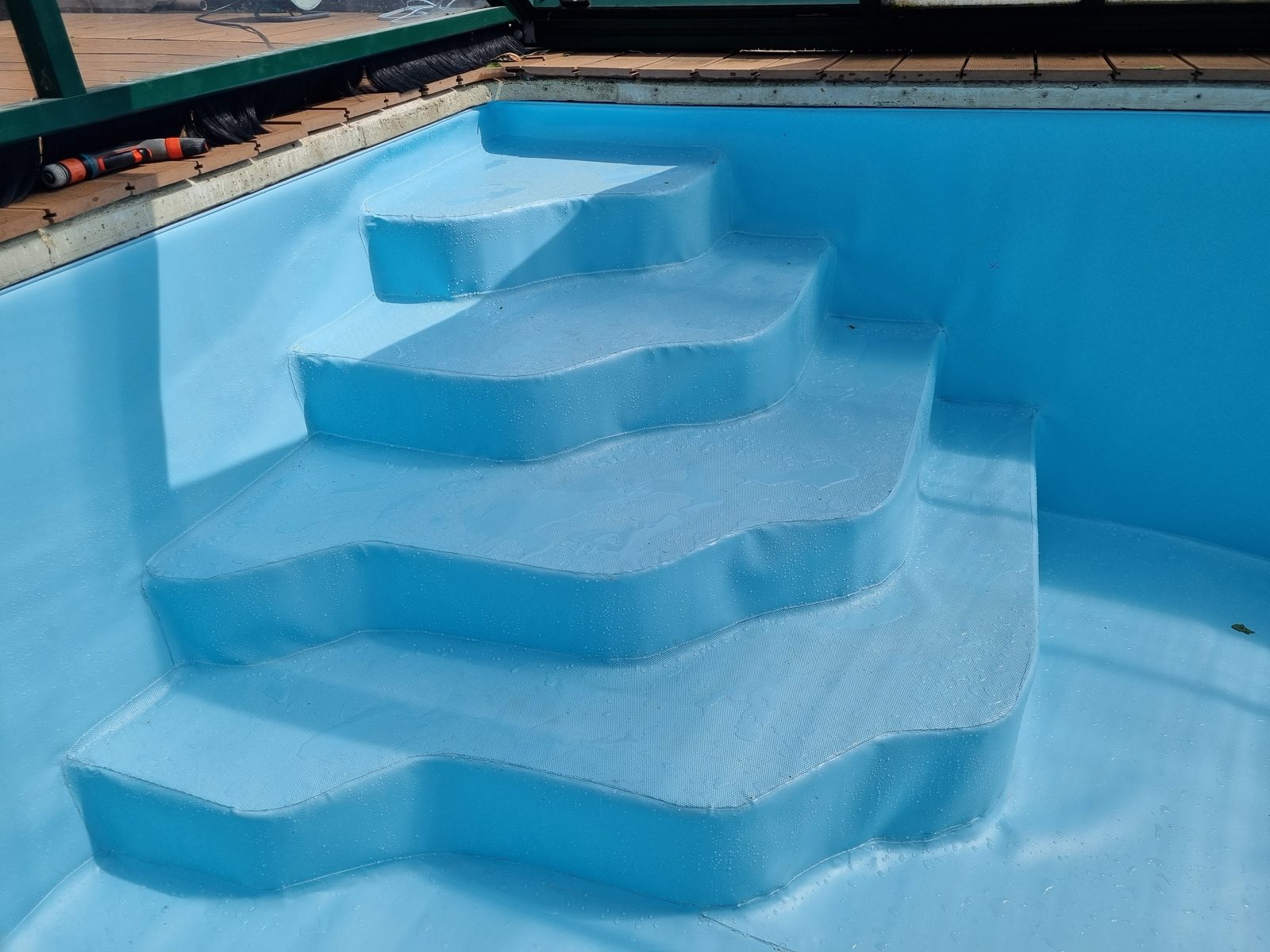 Escalier d'angle entièrement habillé de PVC armé bleu, membrane neuve sous abri télescopique
